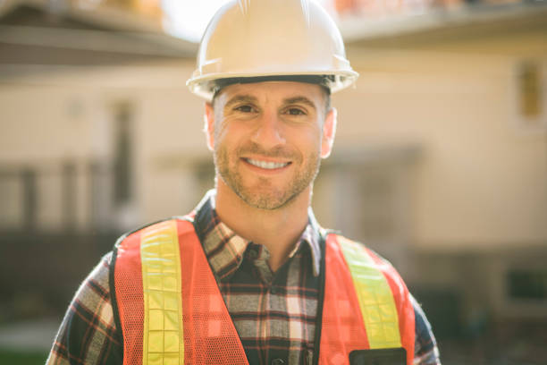istock man with hard hat standing infront of a house 2185402150