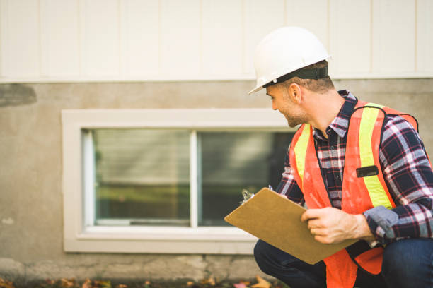 istock Man inspecting house window outside on day light 2185402191