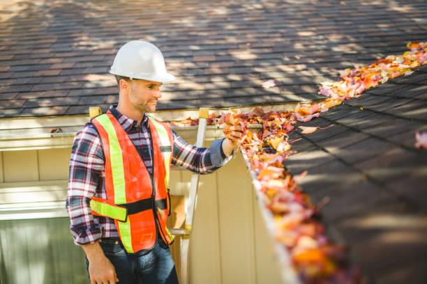 istock man with hard hat standing on steps inspecting house roof 2185402220