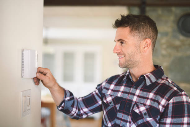 istock A man set the thermostat at house 2185402221