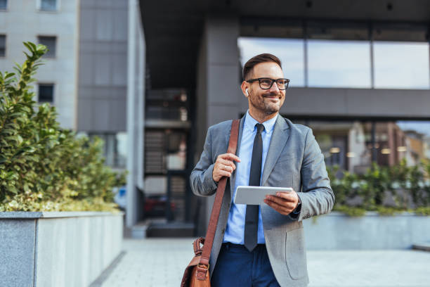 istock Confident Businessman Walking Outside Office Building With Tablet 2185403054