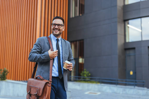 istock Confident Businessman Walking With Coffee Outside Office Building 2185403584