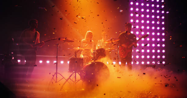 istock Charismatic Drummer Girl Playing Drums at a Live Band Performance Under Falling Confetti. Young Indie Band Playing Rock Music with Alternative Punk Tracks at a Festival with Energetic Visuals 2185404123