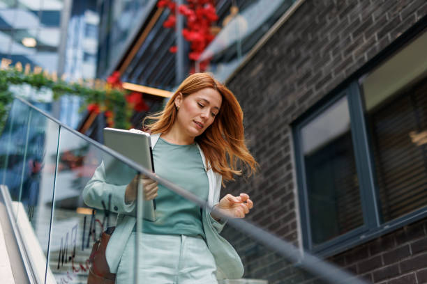 Businesswoman descending steps with focus and hand gesture