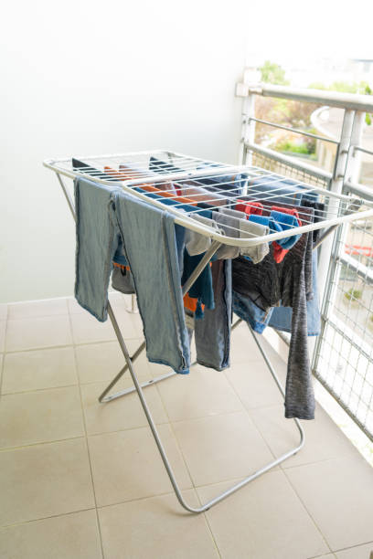 istock Laundry drying on a balcony clothes rack, with various garments including jeans and shirts 2185404724