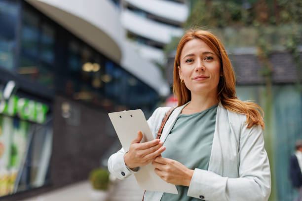 istock Confident female professional holds documents in city setting 2185404734