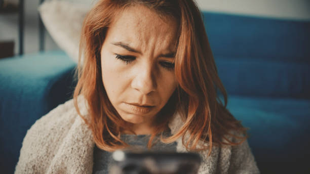 istock Distressed Mid Adult Woman Using Smartphone at Home 2185407175