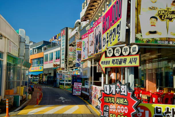 Sokcho, South Korea - November 3rd, 2024: Vibrant seafood restaurants and eateries line the main road at Daepo Port, showcasing colorful signs and offering fresh local seafood to tourists and locals.