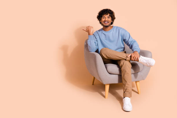 istock Full length photo of funky cool guy dressed blue sweatshirt pointing thumb emtpy space isolated beige color background 2185410664