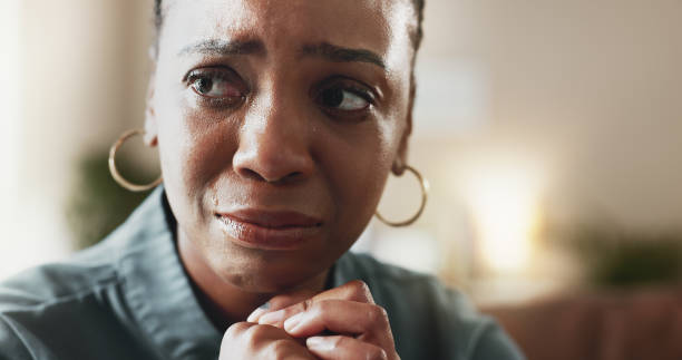 crying, sad face and black woman with depression, thinking and psychological trauma in home living room. tears, unhappy and african person with anxiety for crisis, mental health challenge and stress - pijn fotos stockfoto's en -beelden