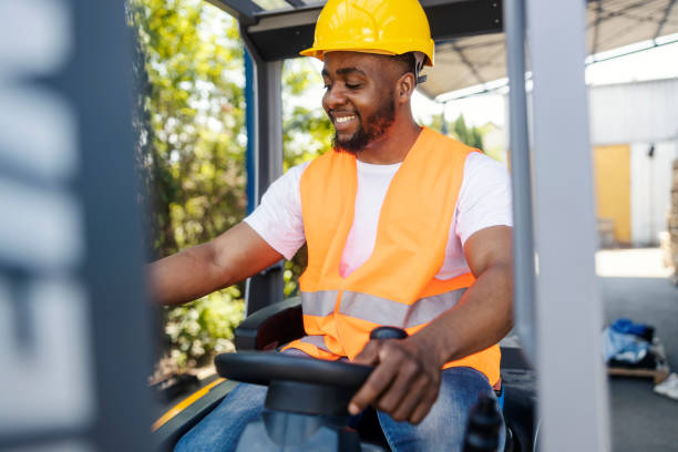 istock Interracial forklift driver in working uniform driving forklift outside of storage. 2185412682