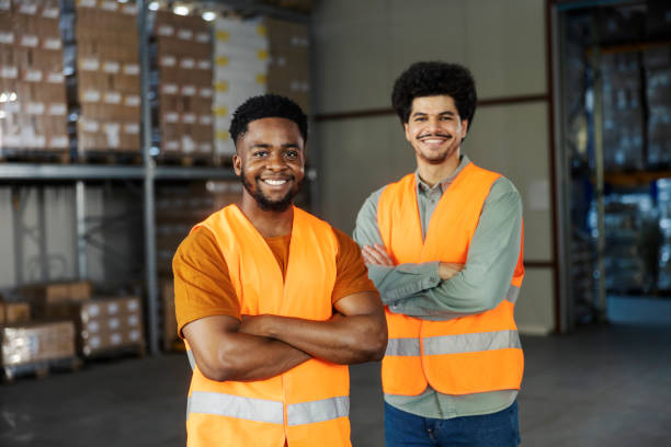 istock Two confident interracial workers standing at storage with arms crossed and smiling at camera. 2185412716