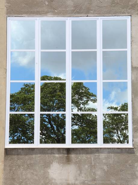 istock Reflection of sky and trees from a glass big window 2185413948