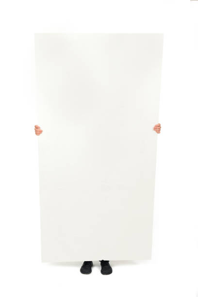 woman holding objects on white background woman showing and covering herself with a large white advertising billboard on white background person holding frame over face stock pictures, royalty-free photos & images