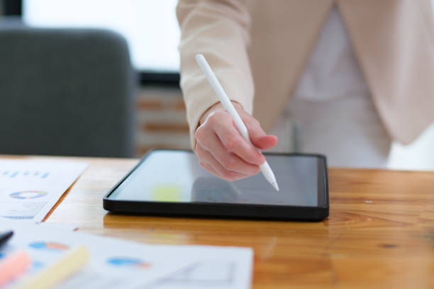 istock Close-up of hand signing electronic documents on a tablet with a digital pen for online workflows 2185420309