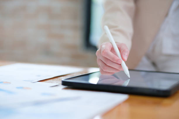 istock Close-up of hand signing electronic documents on a tablet with a digital pen for online workflows 2185420315