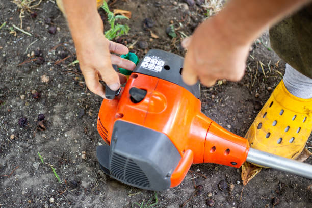 istock Starting a gas mower to cut grass. A man pulls the recoil starter to start the engine 2185420336