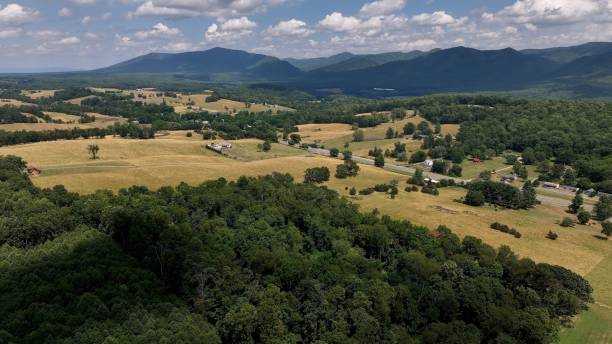 istock Countryside landscape with mountains, green fields, cloud shadows with view of Blue Ridge Mountains on horizon under sunny sky with fluffy clouds 2185420699