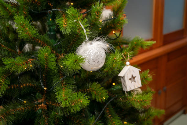 istock A Christmas tree with a white ornament hanging from it. 2185421135