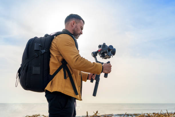 istock Camera Operator Filming Flood-Damaged Vegetation and Debris Washed Ashore on a Beach Using a Gimbal 2185422579