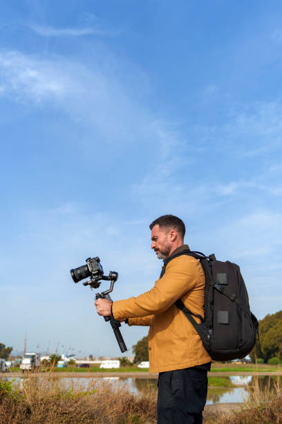 istock Camera Operator Filming Flood-Damaged Vegetation and Debris Washed Ashore on a Beach Using a Gimbal 2185422604