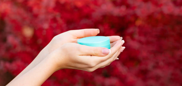 istock hands holding moisturizing cream jar for skincare 2185422645