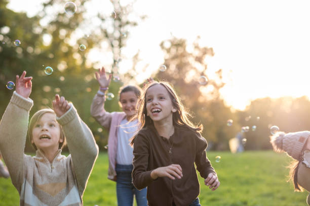 istock children play with soap bubbles in nature 2185423840