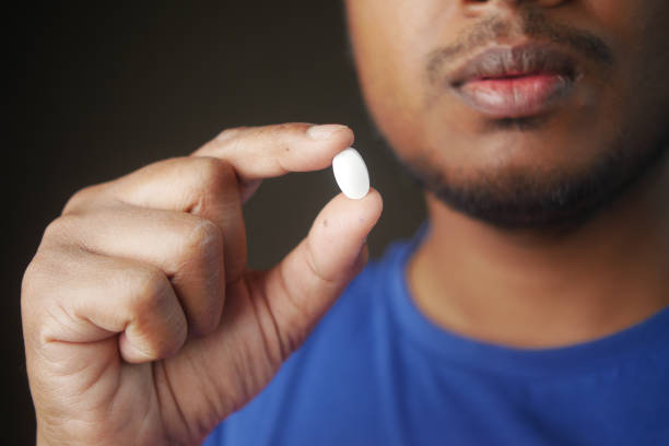 istock Close up of man hand holding pills with copy space 2185425142