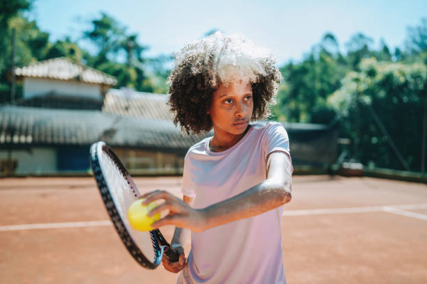 istock child playing tennis serve 2185425660
