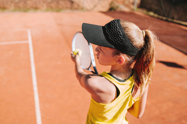 istock child playing tennis serve 2185425905