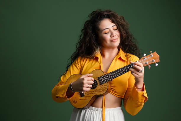 A Hawaiian musician plays the ukulele during a traditional performance, wearing a floral dress and lei that reflect the warmth and culture of the islands.