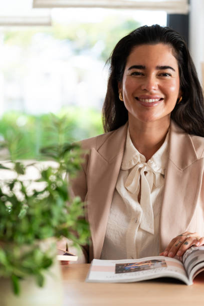 istock Young hispanic entrepreneur smiling and reading magazine 2185432090