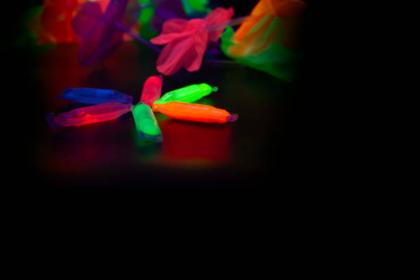 Abstract neon objects arranged on a dark reflective surface