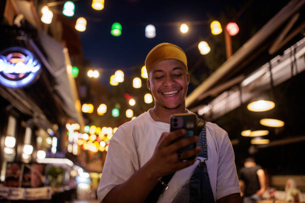 Handsome black male tourist using smart phone on the street in Istanbul, Turkey at night.
