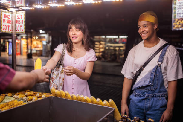 istock Couple buying corn on the street 2185433866