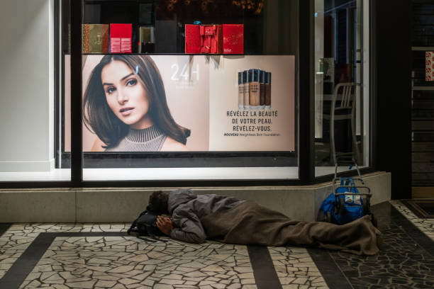 Nice, France - October 22, 2024: Homeless man sleeps under a store window