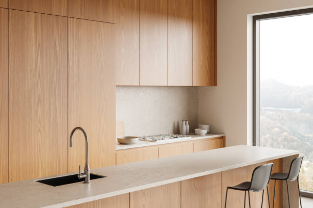 istock Beige home kitchen interior with bar island, cooking cabinet and panoramic window 2185434088