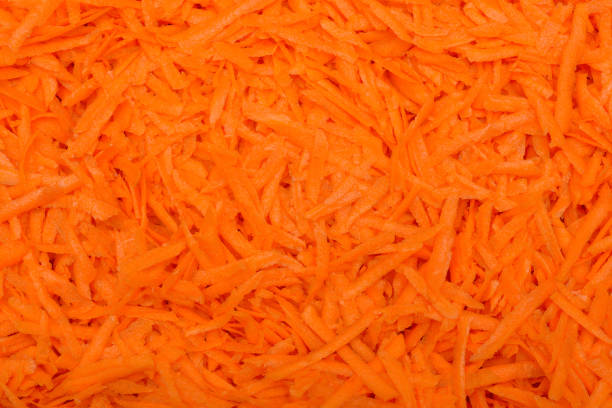 Full frame of grated fresh carrots as background or texture. Home cooking.