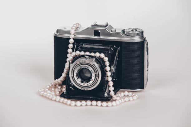 istock old 20th century photo camera with retractable lens on light background 2185435351