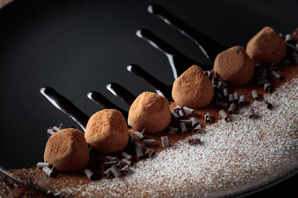 istock Chocolate truffles on a black plate with chocolate sauce. 2185439474