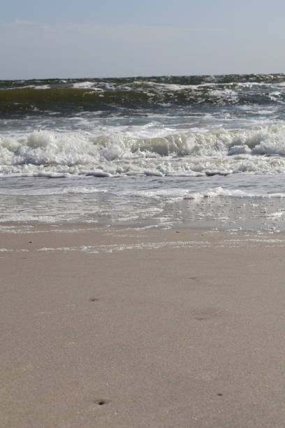istock Foamy Ocean Waves on a Sandy Beach 2185445378