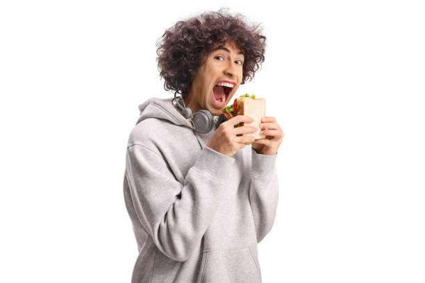 istock Young man with open mouth holding a sandwich 2185449254