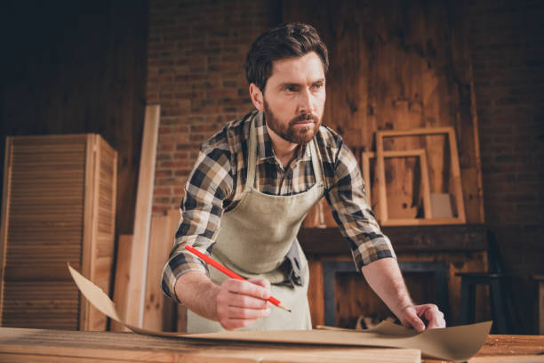 istock Photo of builder artisan guy look profile side thoughtful write blueprint in garage 2185452005