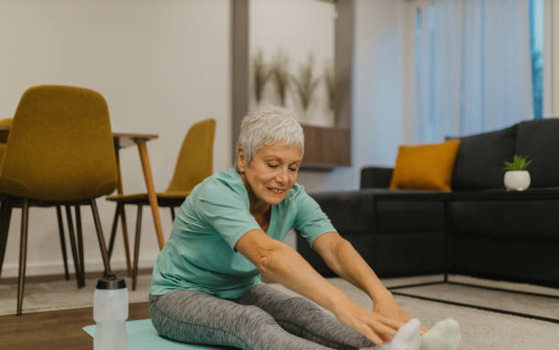 istock Senior woman stretching on an exercise mat at home 2185454836