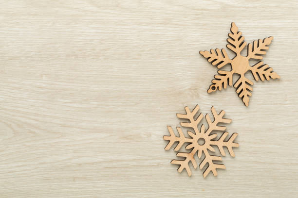 Beautiful snowflake on wooden background, top view