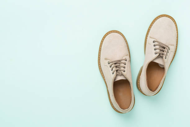 istock Beige suede shoes on color background, top view 2185459215