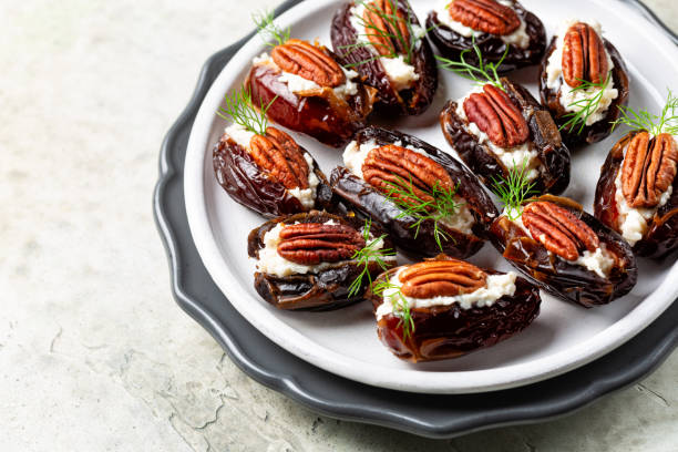 istock Stuffed Dates with goat cheese, mayonnaise, pecan nuts. Festive appetizers, White table surface. 2185461416