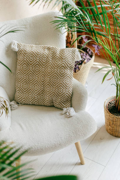 Cozy corner featuring a textured cushion beside indoor plants in a bright room