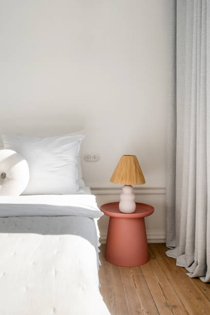 istock Relaxing bedroom with natural decor featuring a soft bedside lamp and curtains 2185464046