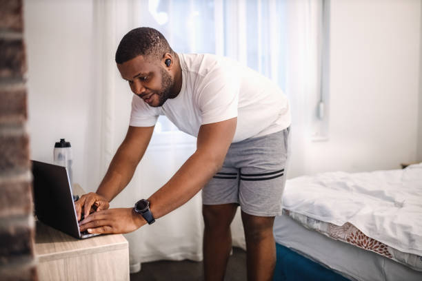 istock Young black man using laptop to play music for his home workout 2185464465